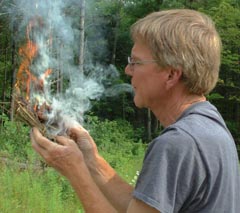 Jim holding flaming tinder bundle